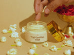Hand taking a small amount of Deiveegaa Gopi Chandhan Tilak paste from the jar